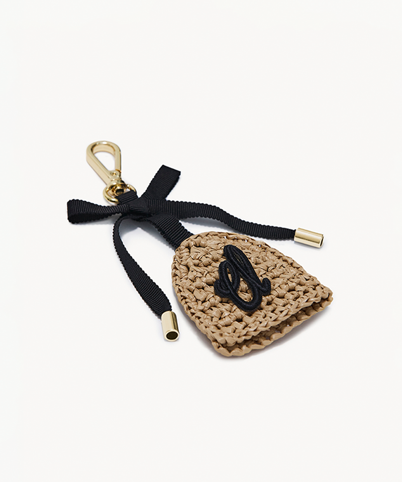Crocheted keychain with a black ribbon and gold accents on a white background